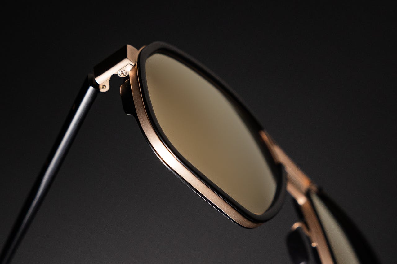 Close-up of stylish modern sunglasses with a sleek metallic frame, showcasing luxury eyewear design.
